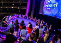 Attendees participating in a group activity at Mindvalley University on stage